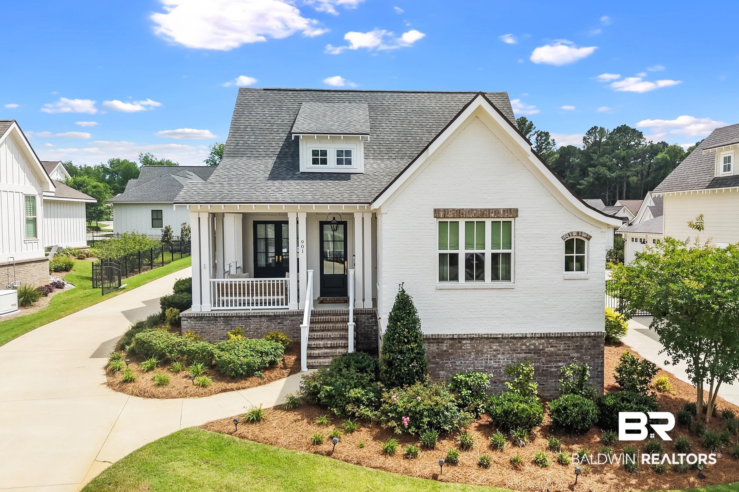 Image 2: White brick exterior with a dark shingle roof and contrasting dark trim