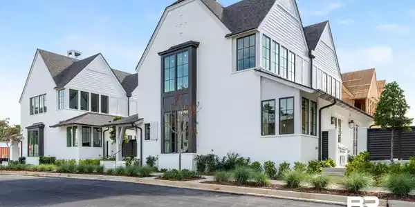 Image 4: Modern farmhouse style home with a shingled roof and brick siding