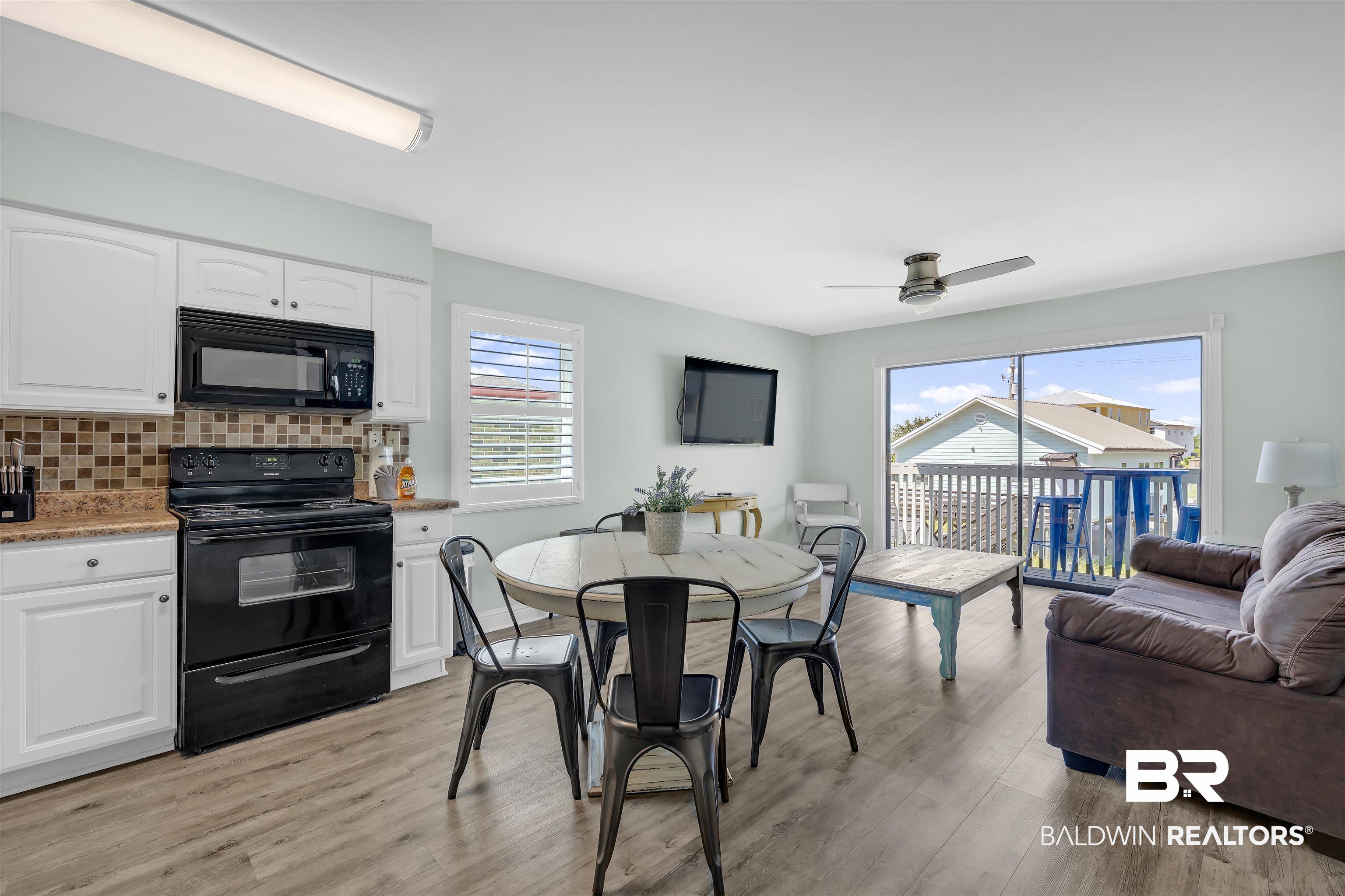 Image 3: Dining room with light wood finished floors and a ceiling fan