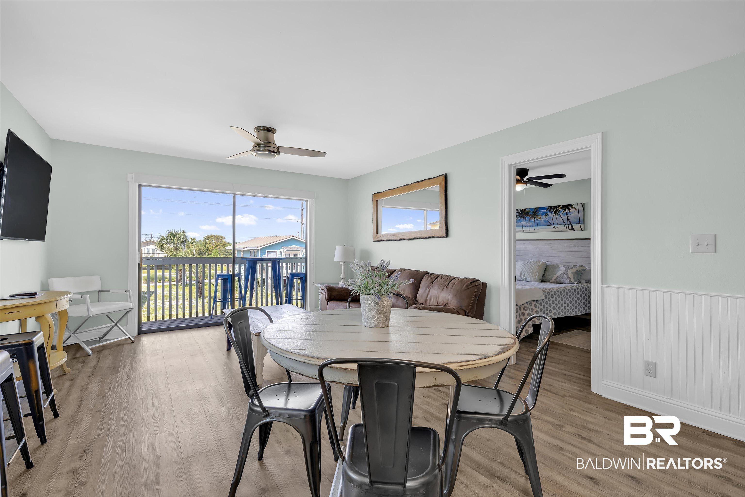 Image 4: Dining area featuring ceiling fan, light wood-style flooring, and a wainscoted wall