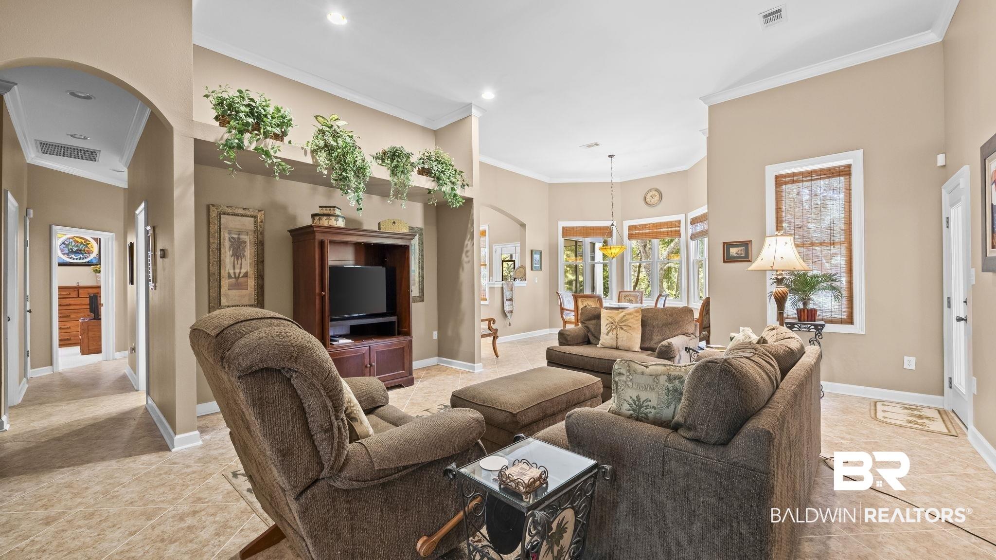 Image 4: Spacious interior featuring tile flooring, vaulted ceilings, recessed lighting, and an arched doorway