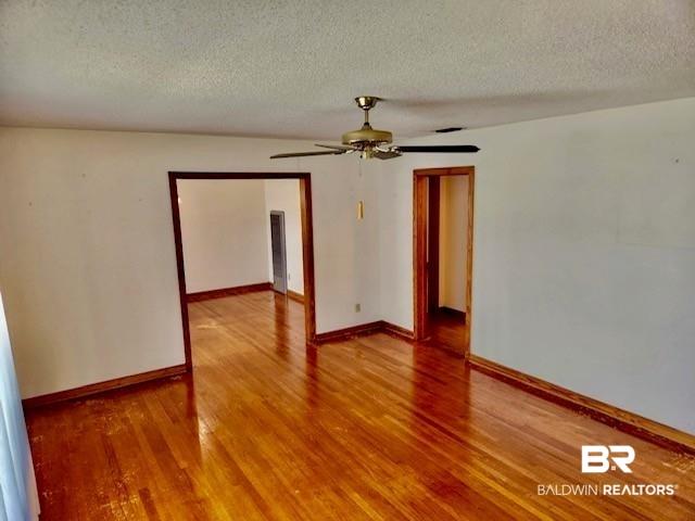 Image 3: Hardwood flooring extends throughout this interior space, complemented by a ceiling fan