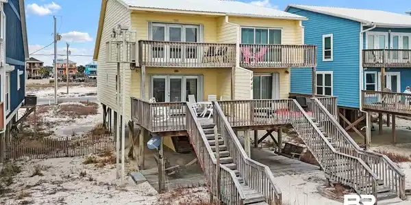 Image 2: Rear view of house featuring a metal roof and a balcony