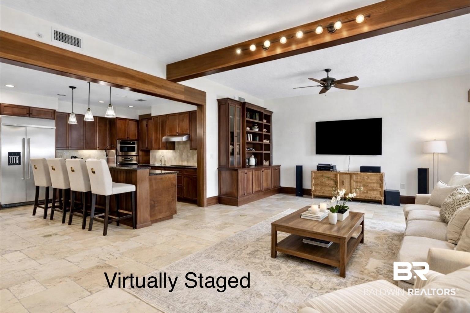 Image 4: Virtually staged living room with beam ceiling, a ceiling fan, and stone tile floors