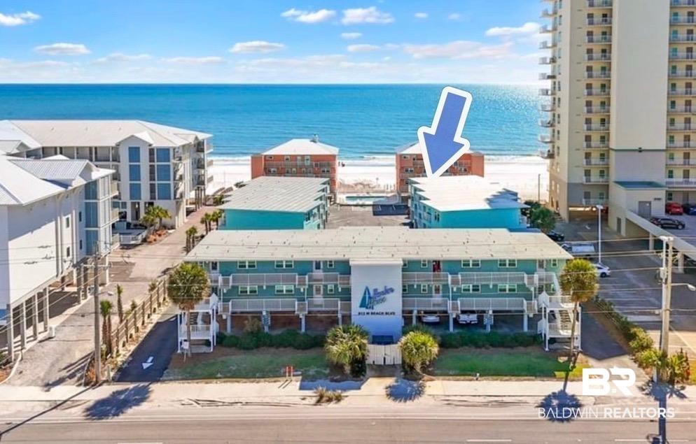 Image 1: Waterfront multi-story building with a light blue exterior and white trim