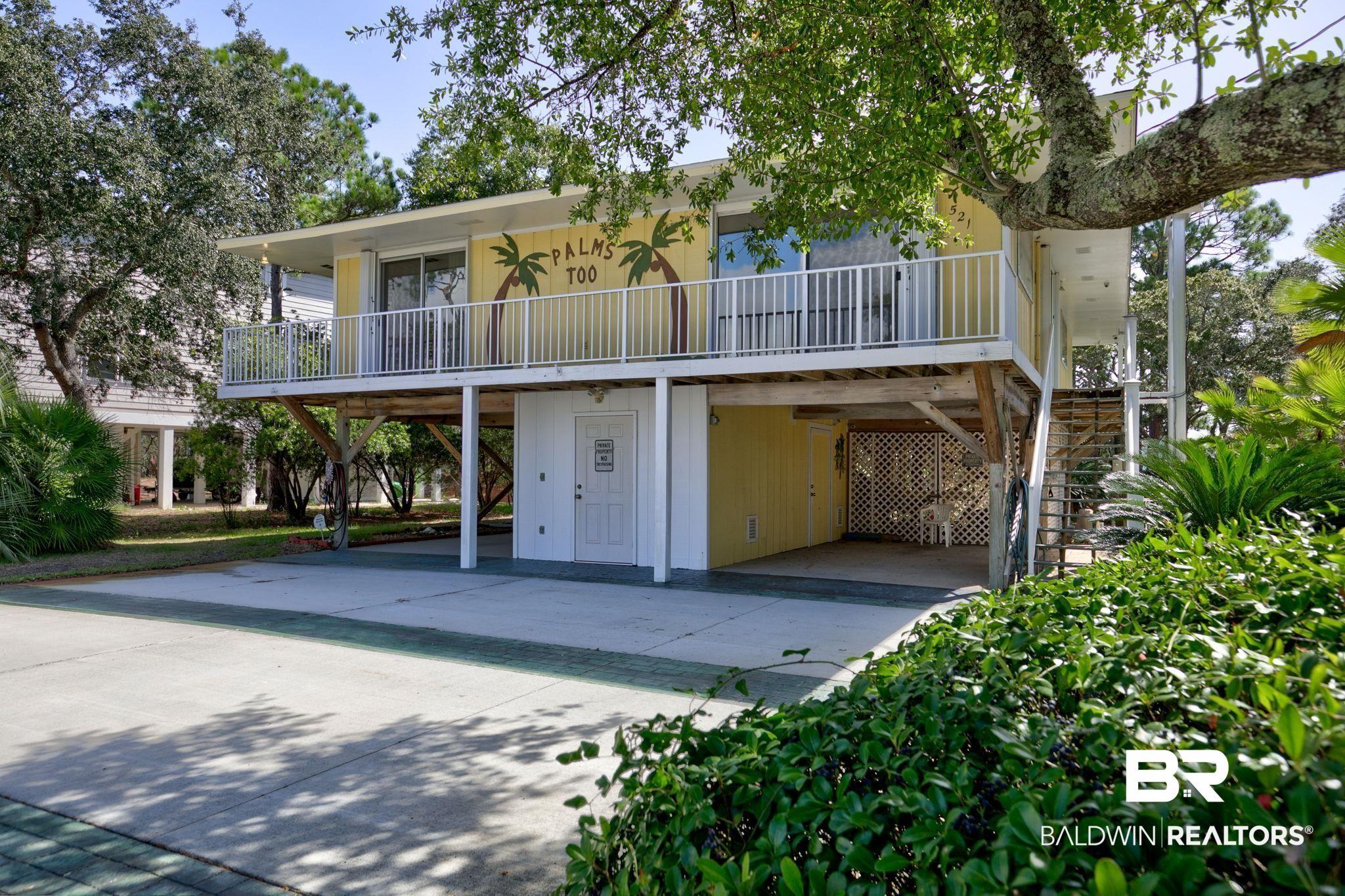 Image 2: View of front facade with stairs, a carport, and driveway
