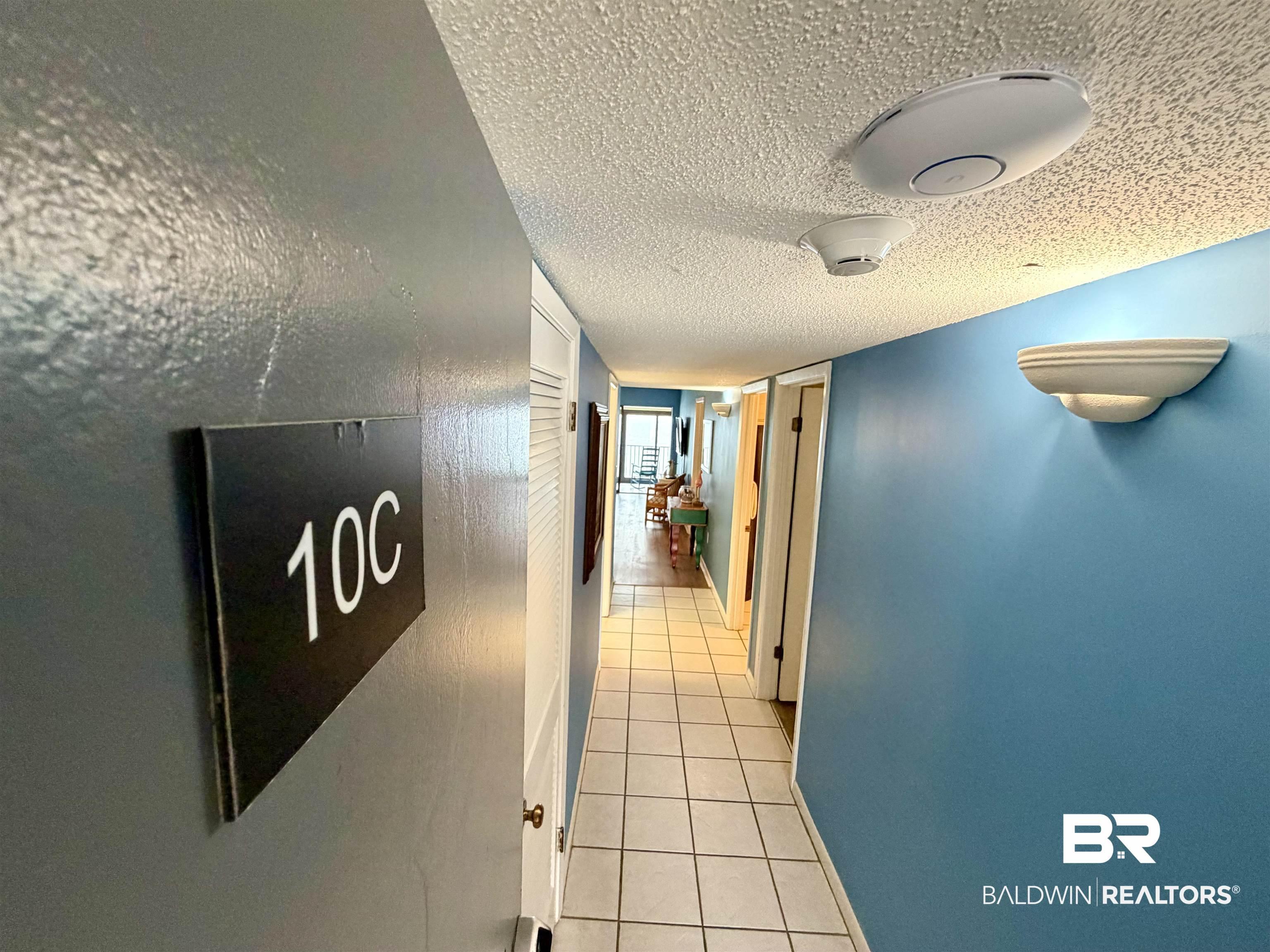 Image 2: Hallway featuring a textured ceiling and light tile patterned floors