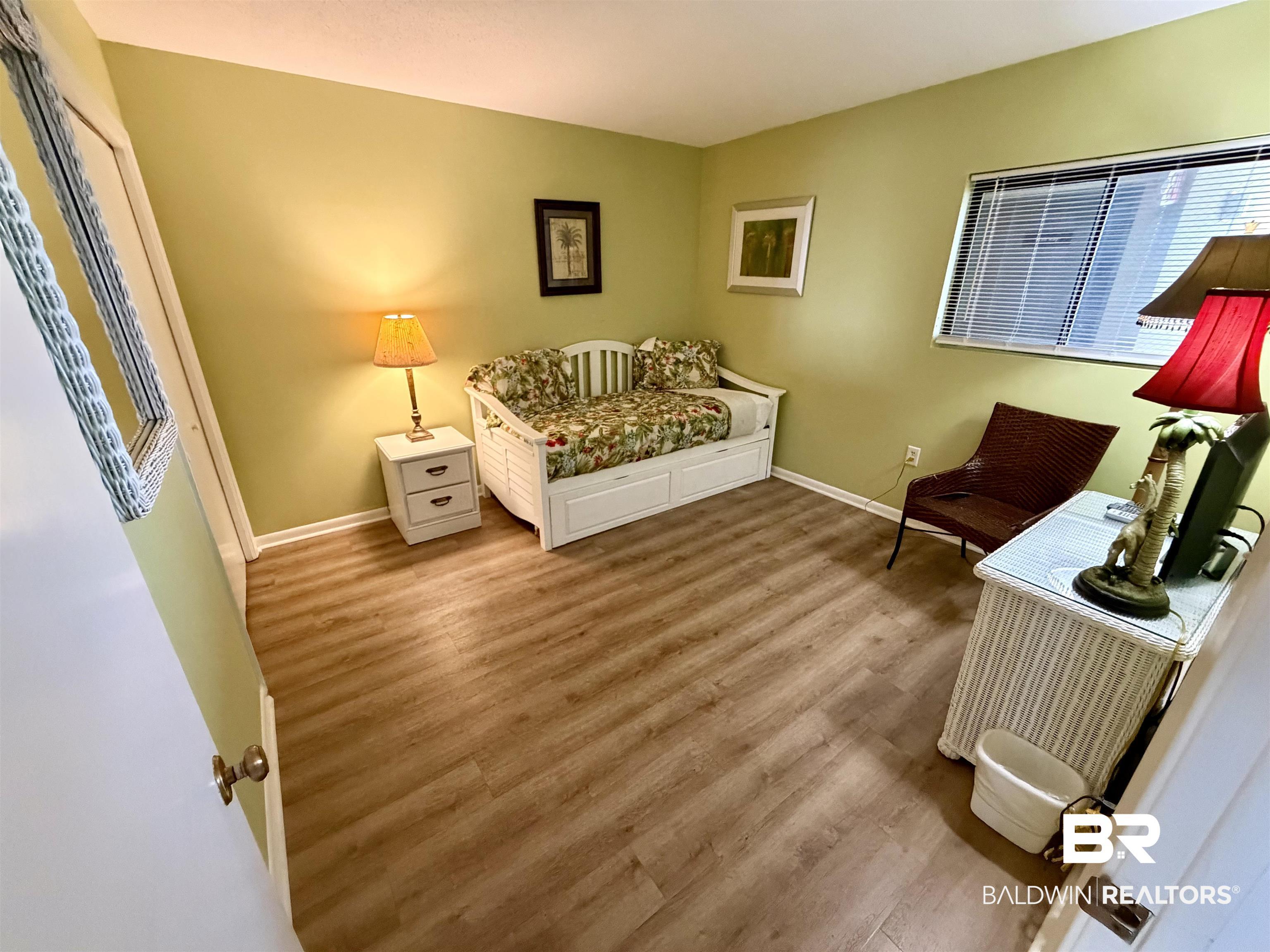 Image 3: Living area featuring wood finished floors and baseboards