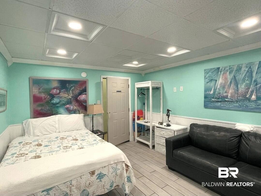 Image 3: Bedroom with a drop ceiling, wood tiled floors, wainscoting, and recessed lighting