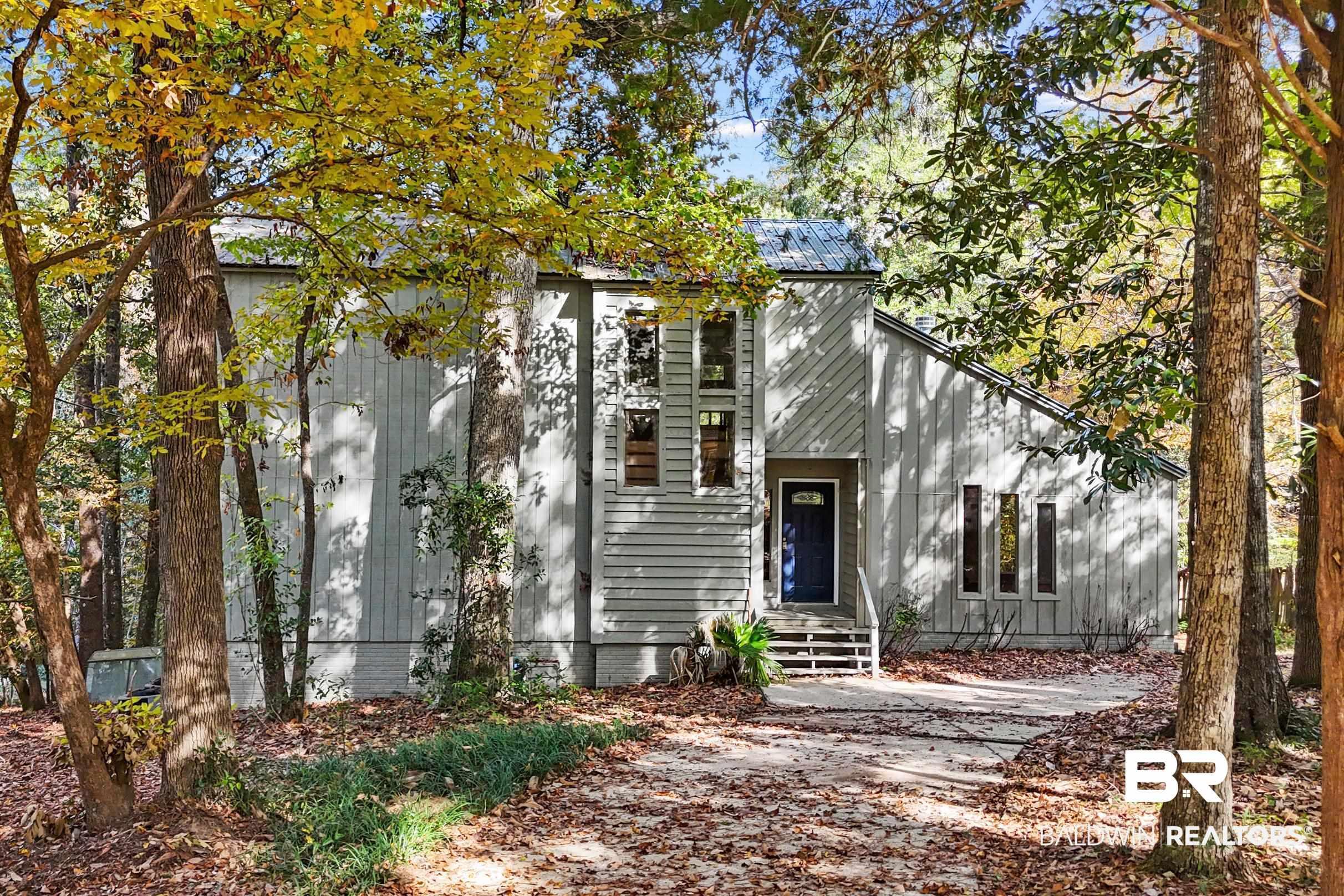 Image 3: Contemporary home exterior featuring vertical siding and a dark blue entry door