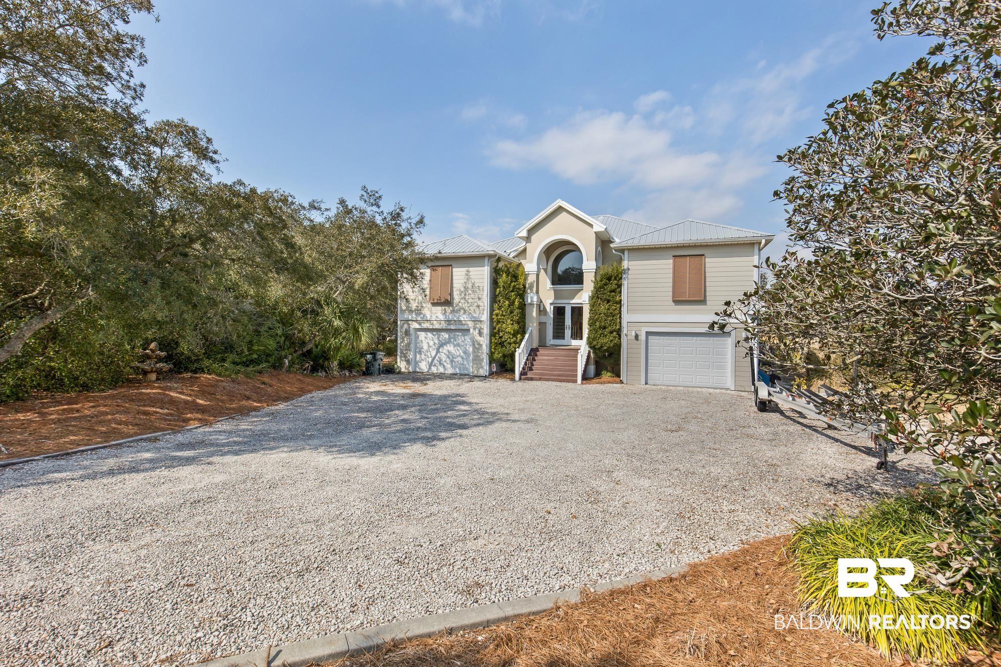 Image 2: View of front of home with driveway, a garage, and a metal roof