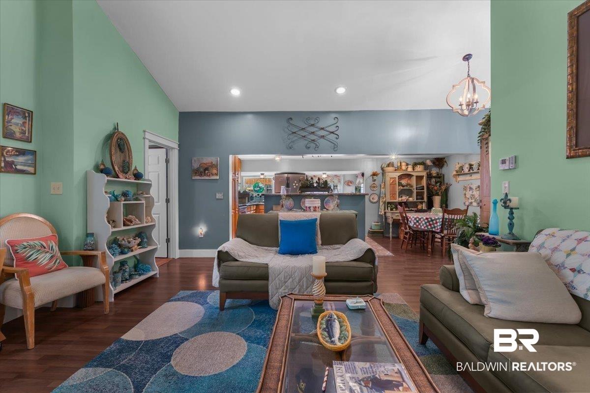 Image 4: Vaulted ceiling great room with wood-finish flooring, recessed lighting, and an open concept layout