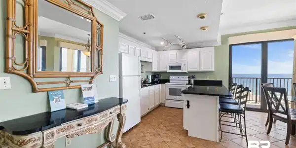 Image 2: Kitchen featuring white cabinetry, dark countertops, and tile flooring
