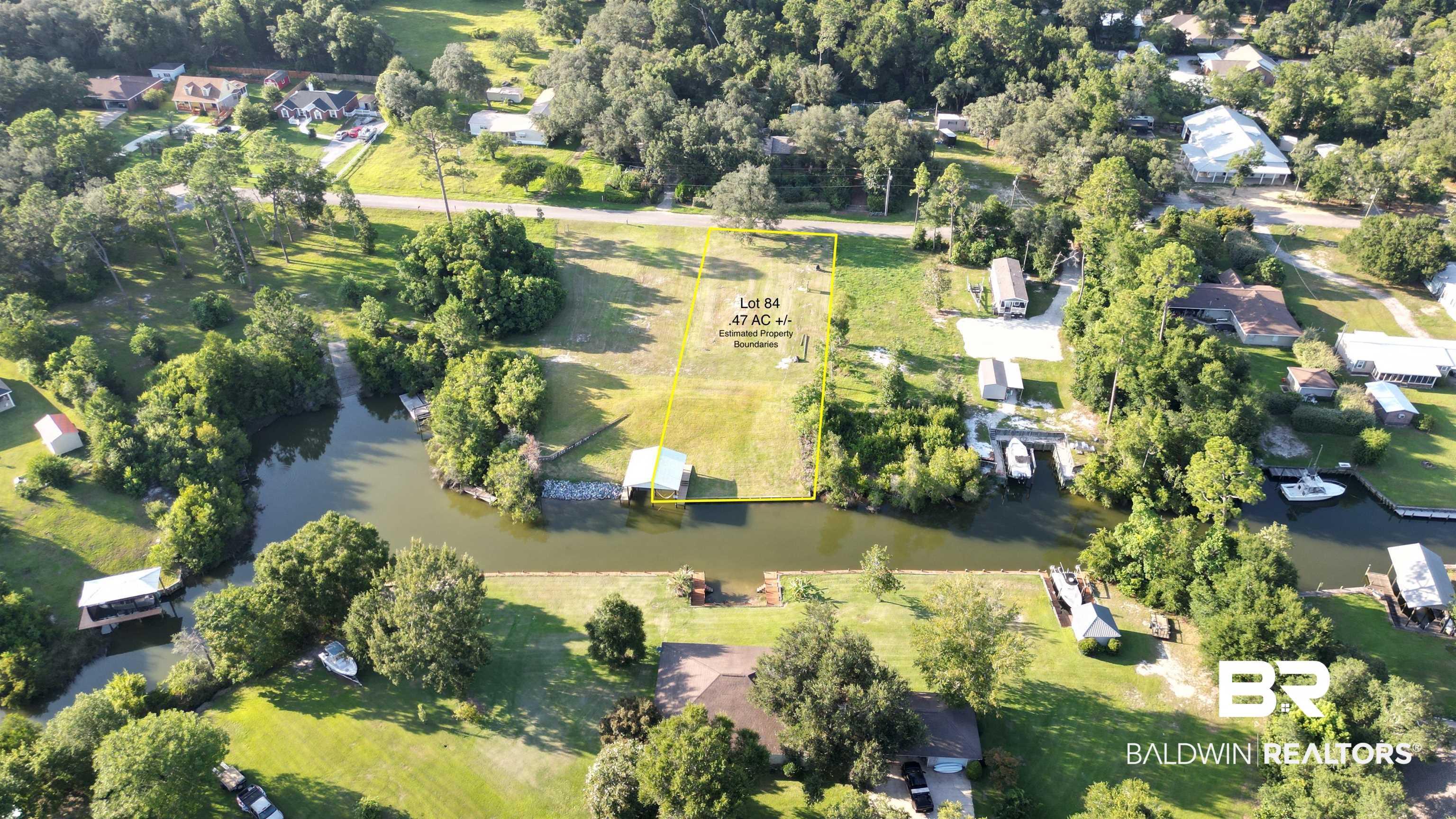Image 2: Aerial view of property's location featuring property boundaries highlighted and a nearby body of water