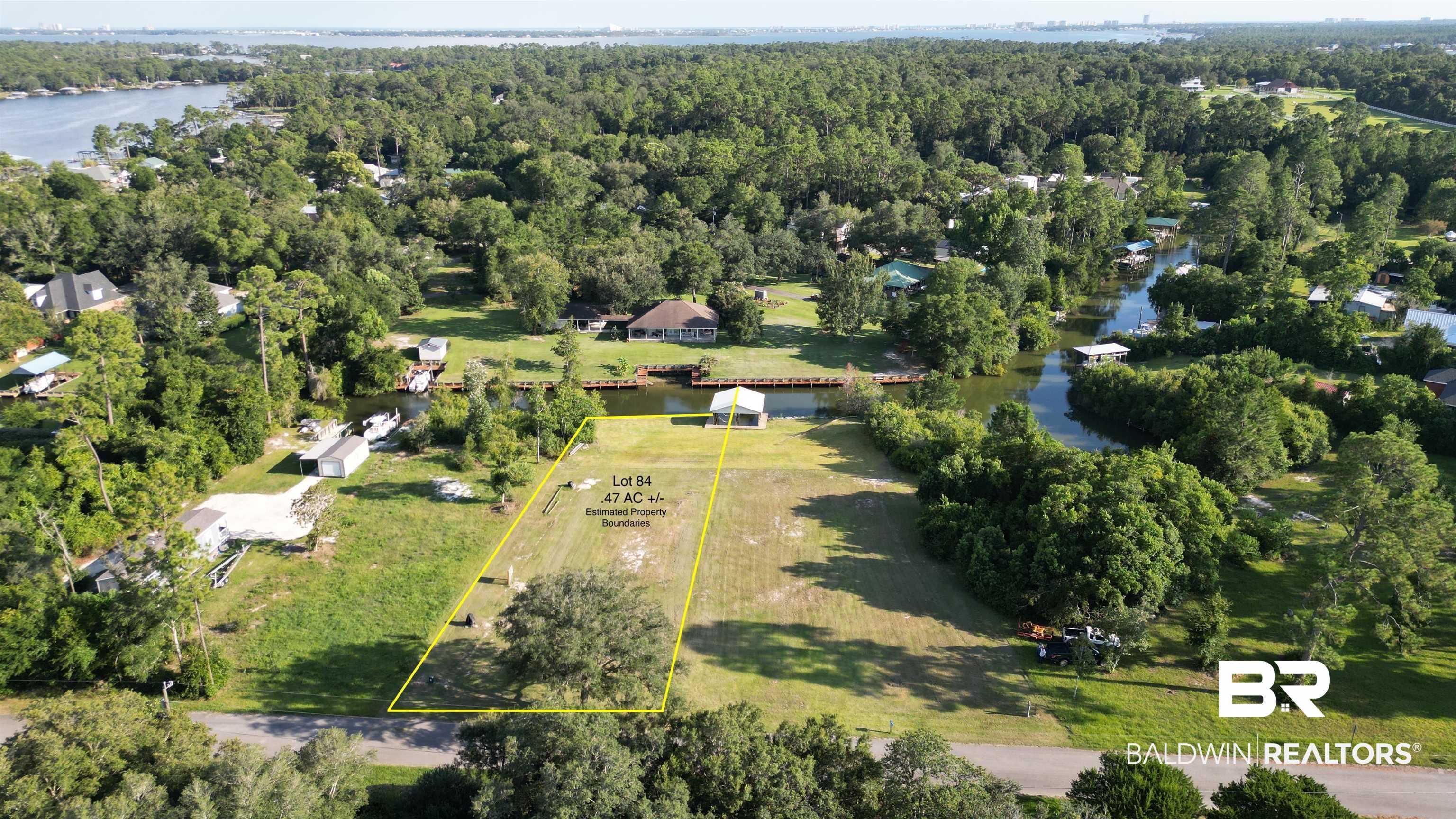 Image 3: Aerial view of property and surrounding area featuring a large body of water and property parcel outlined