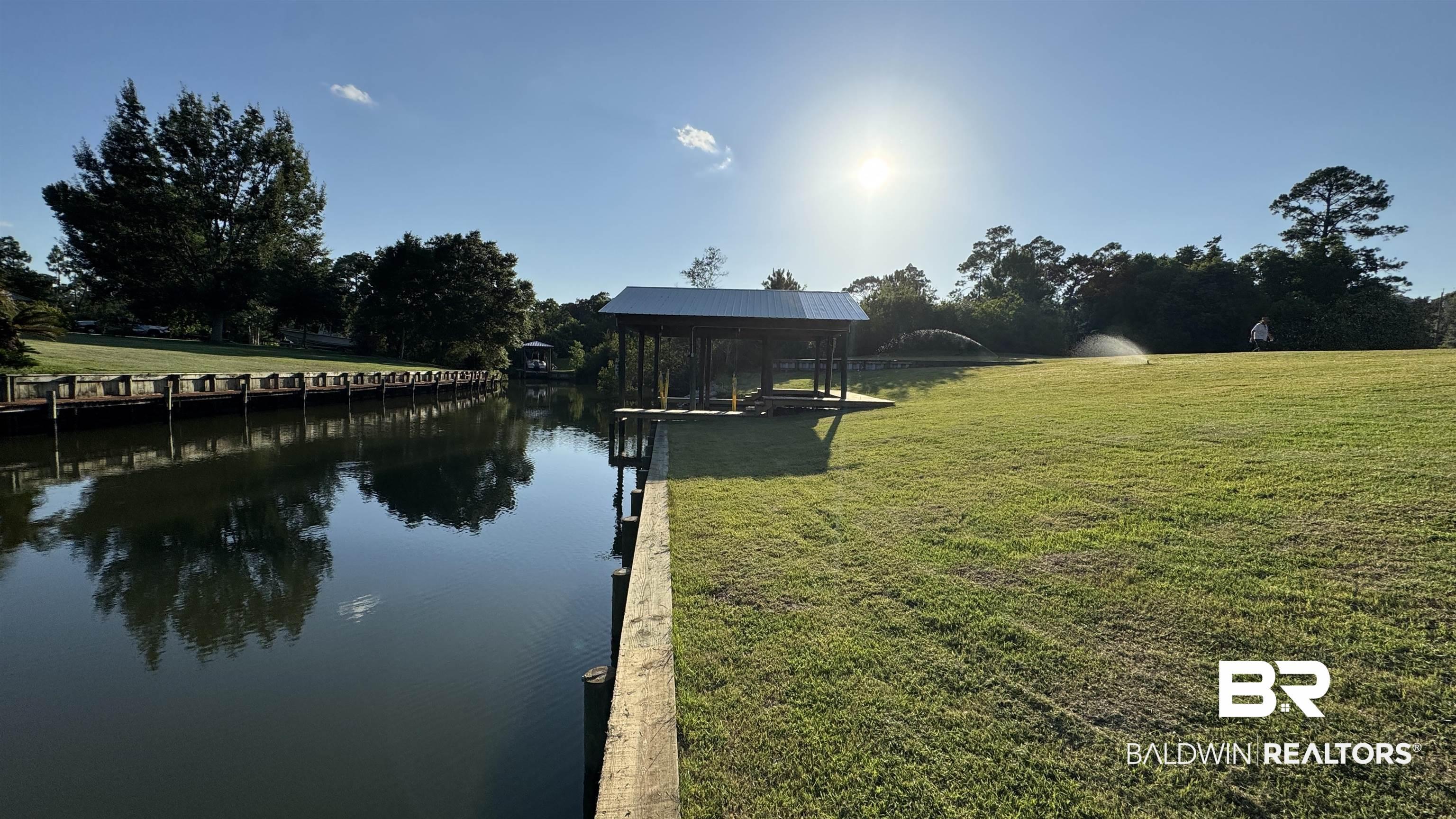 Image 4: Dock area featuring a yard and a water view