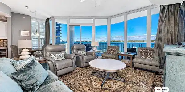 Image 2: Living area with expansive windows, ceiling fan, and a textured ceiling