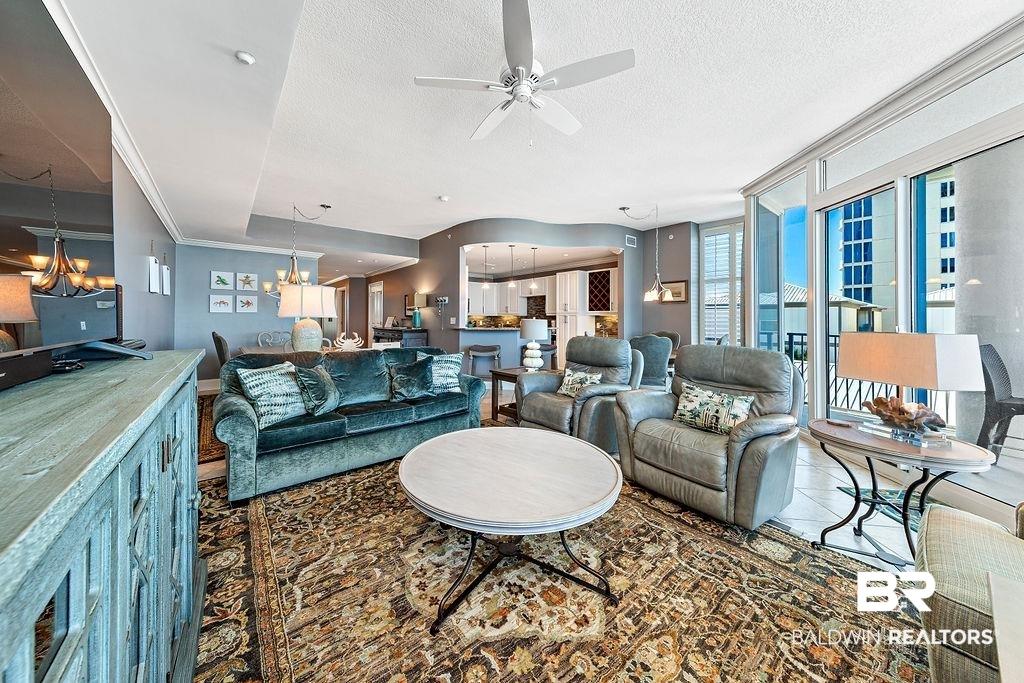 Image 3: Living room featuring ceiling fan, a chandelier, a textured ceiling, and expansive windows