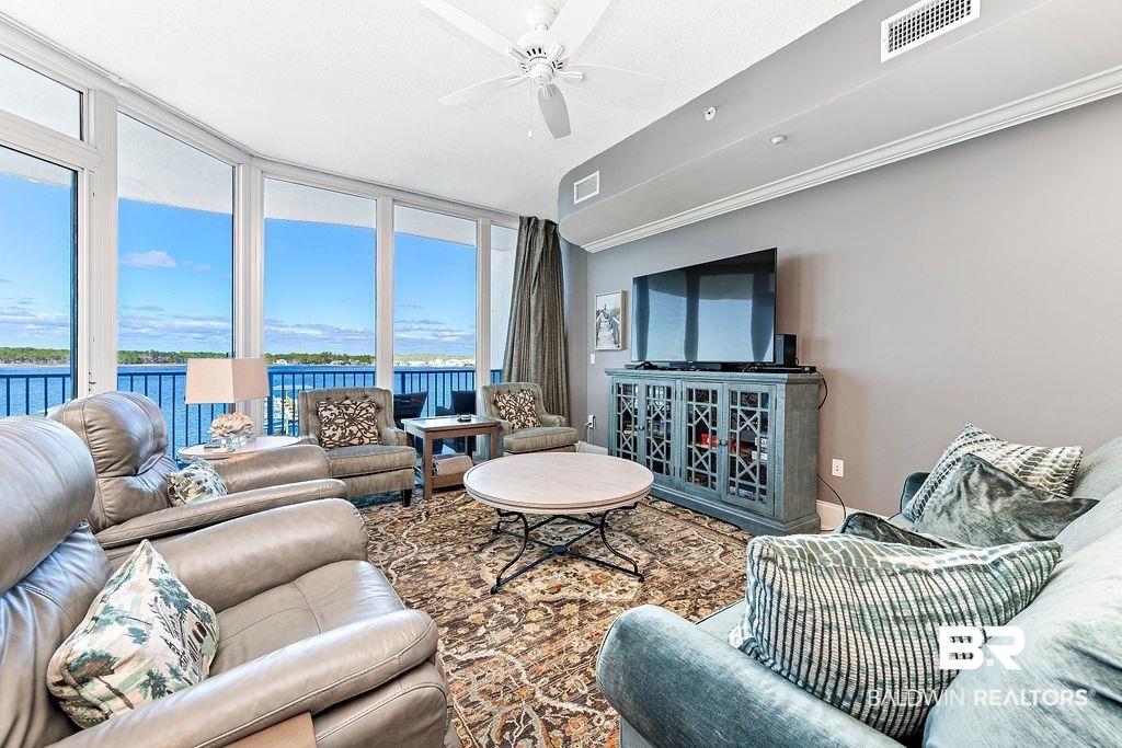 Image 4: Living area featuring a ceiling fan and floor to ceiling windows