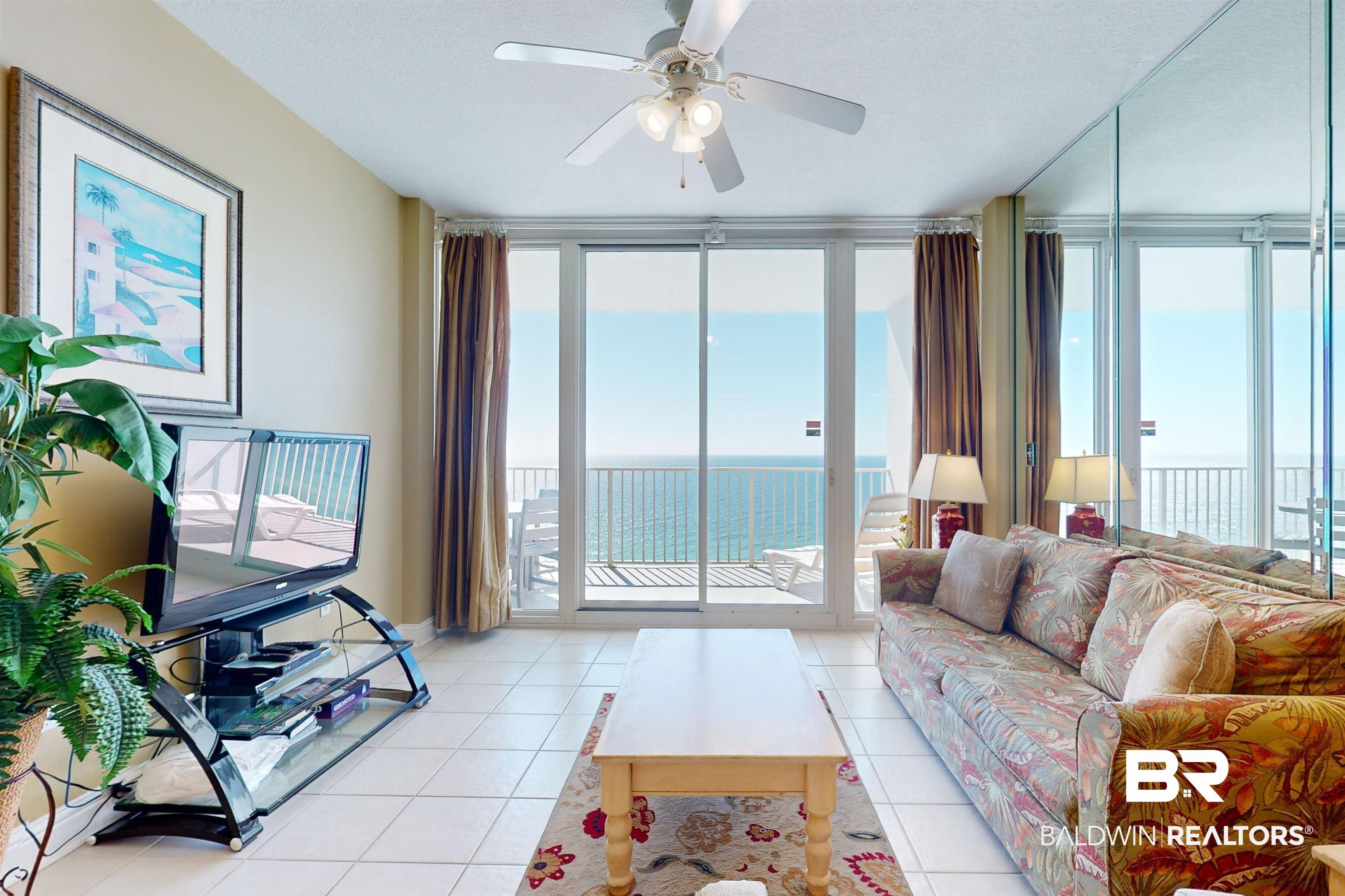 Image 3: Living room featuring light tile patterned floors, expansive windows, and ceiling fan