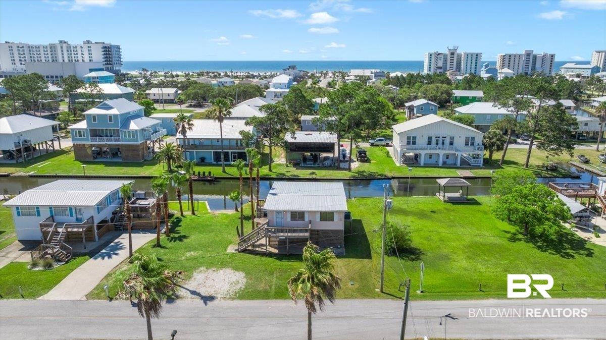 Image 3: Waterfront property featuring a canal, private dock, lush green lawn, and palm trees
