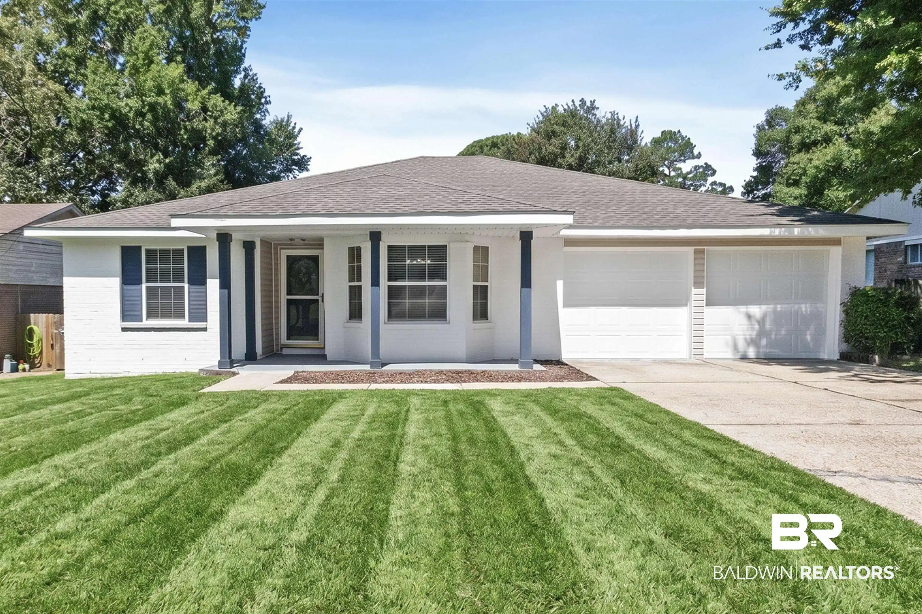 Image 1: White brick exterior with a dark shingle roof and a two-car garage