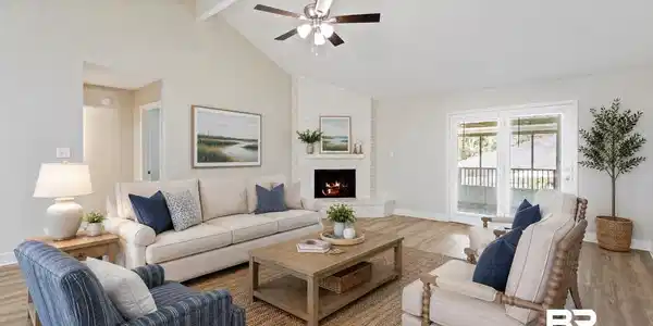 Image 4: Living area with vaulted ceilings, wood-finish flooring, a white brick fireplace, and sliding glass doors