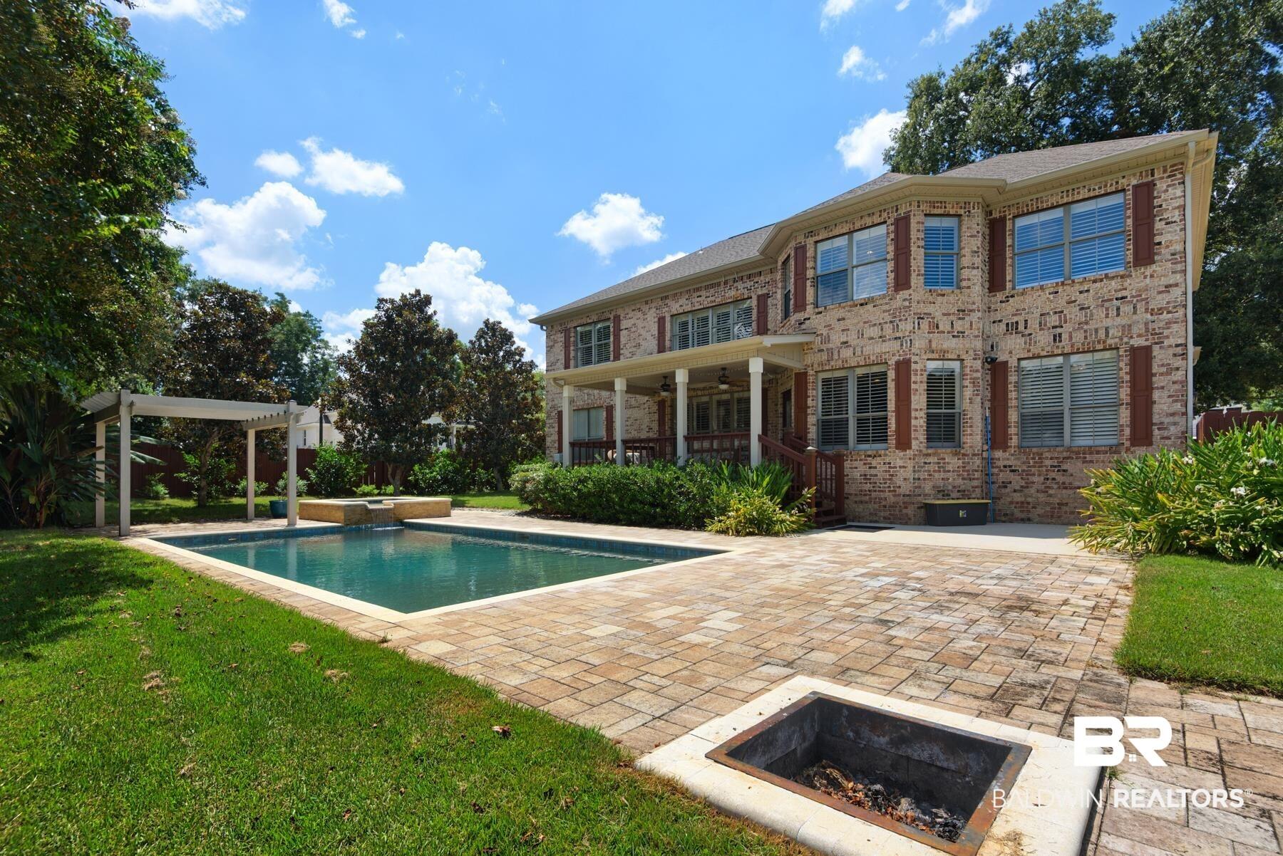 Image 2: Back of property with a patio area, a fire pit, brick siding, and a ceiling fan