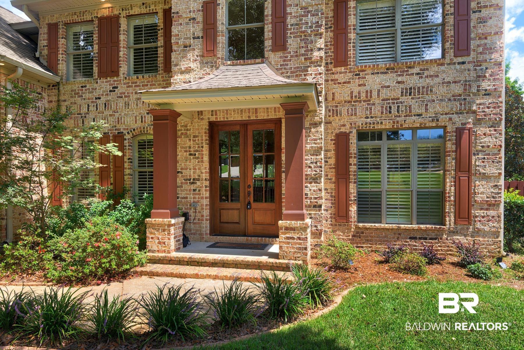 Image 4: Property entrance with french doors, brick siding, and a porch