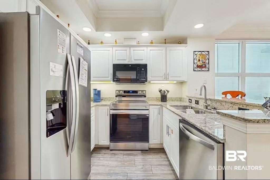Image 4: Kitchen featuring stainless steel appliances, white cabinetry, recessed lighting, and granite countertops