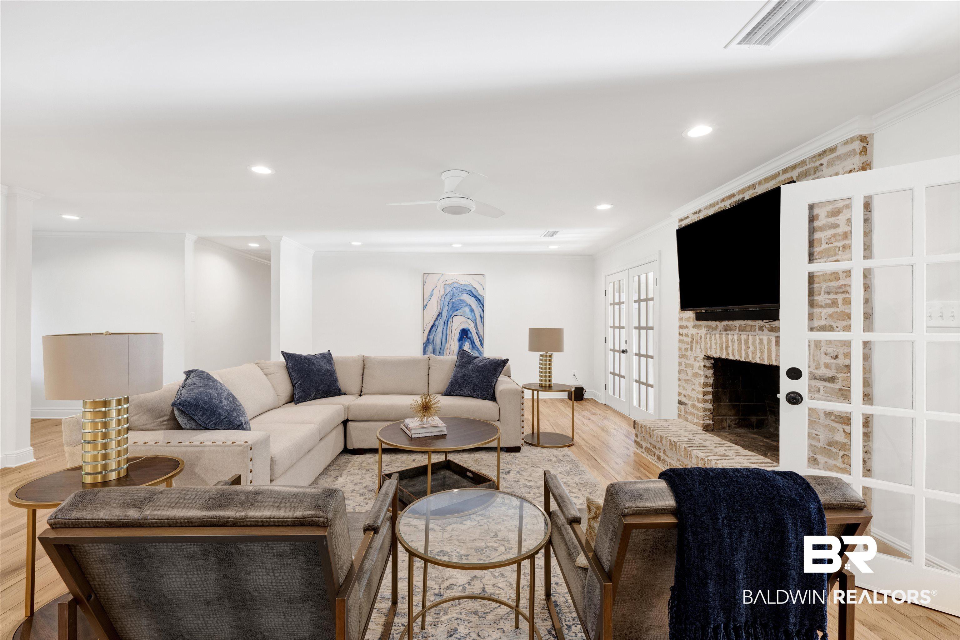 Image 3: Living area with light wood-style flooring, a ceiling fan, a fireplace, and recessed lighting