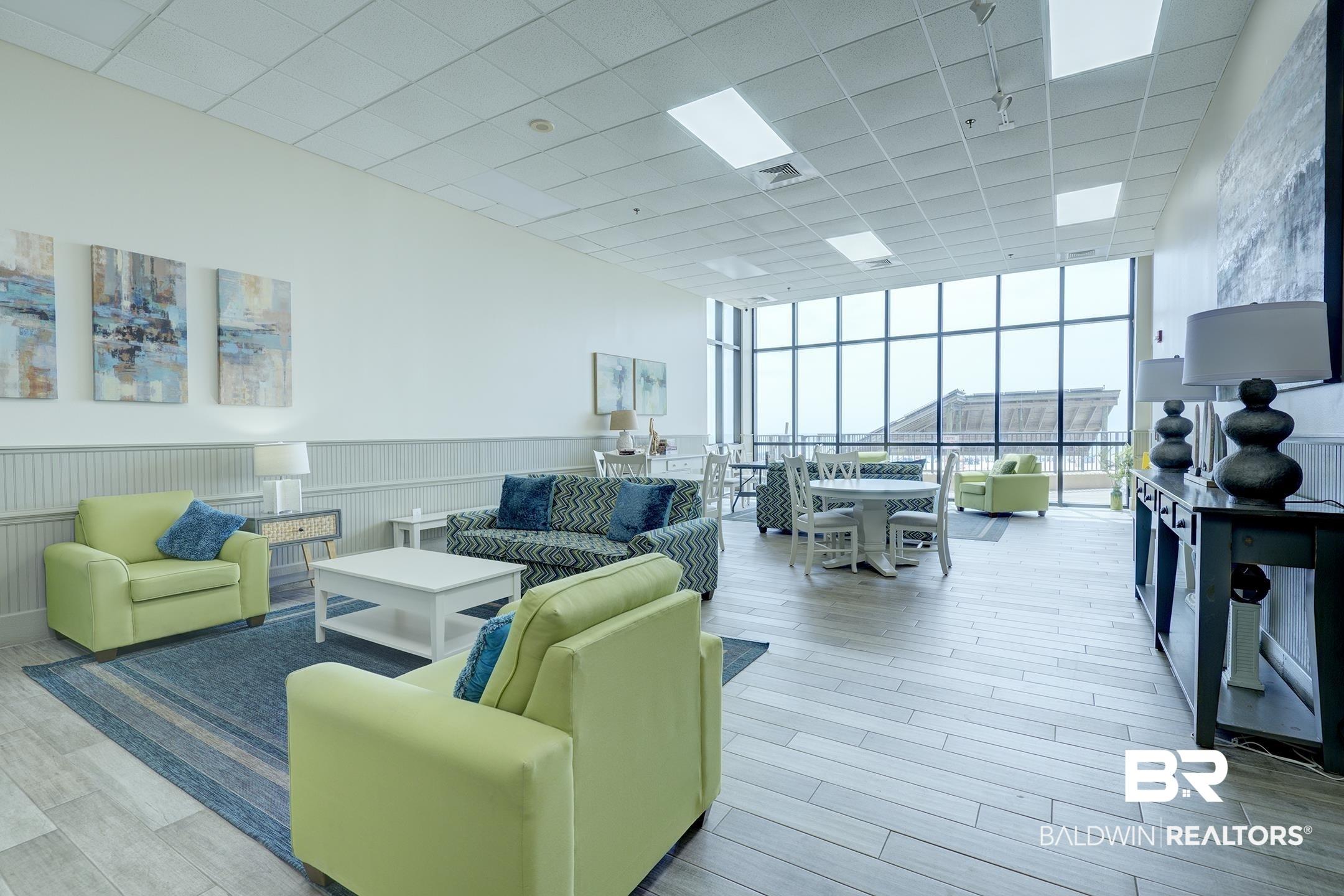 Image 3: Community lobby featuring floor to ceiling windows, a drop ceiling, and wainscoting