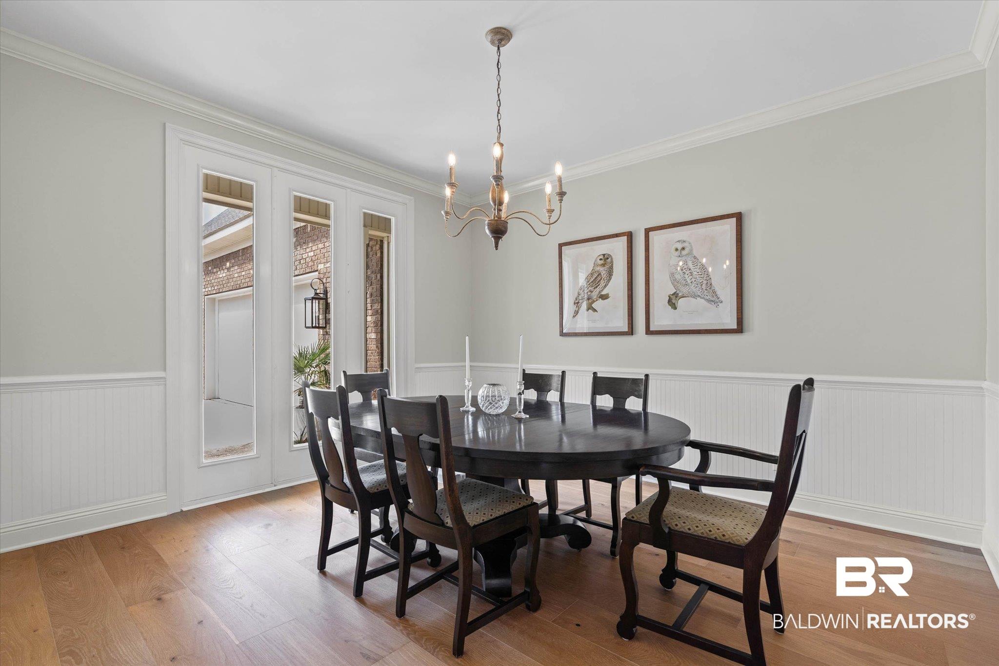 Image 3: Room featuring light wood-finish flooring, white wainscoting, and crown molding