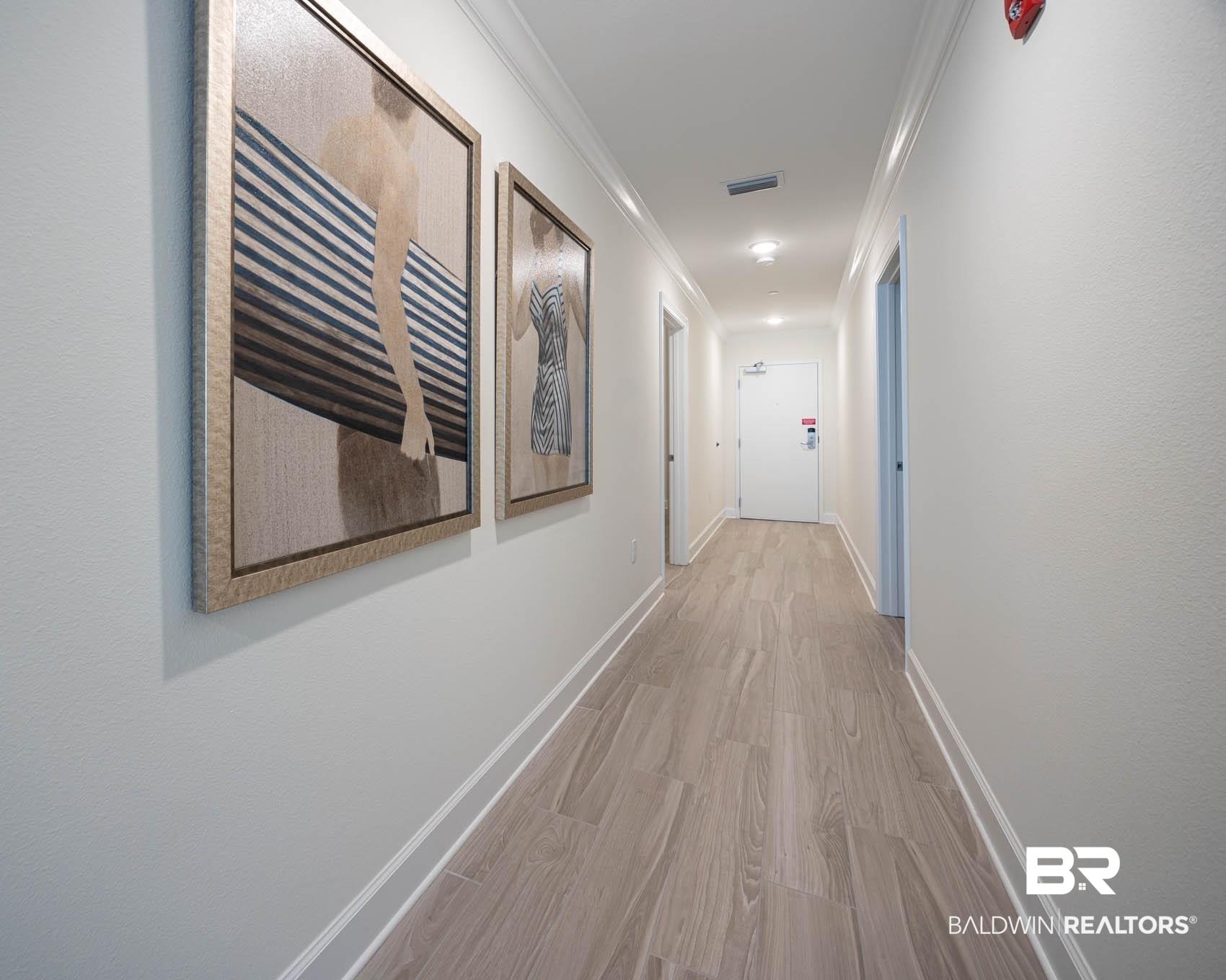Image 4: Hallway with wood finished floors and ornamental molding