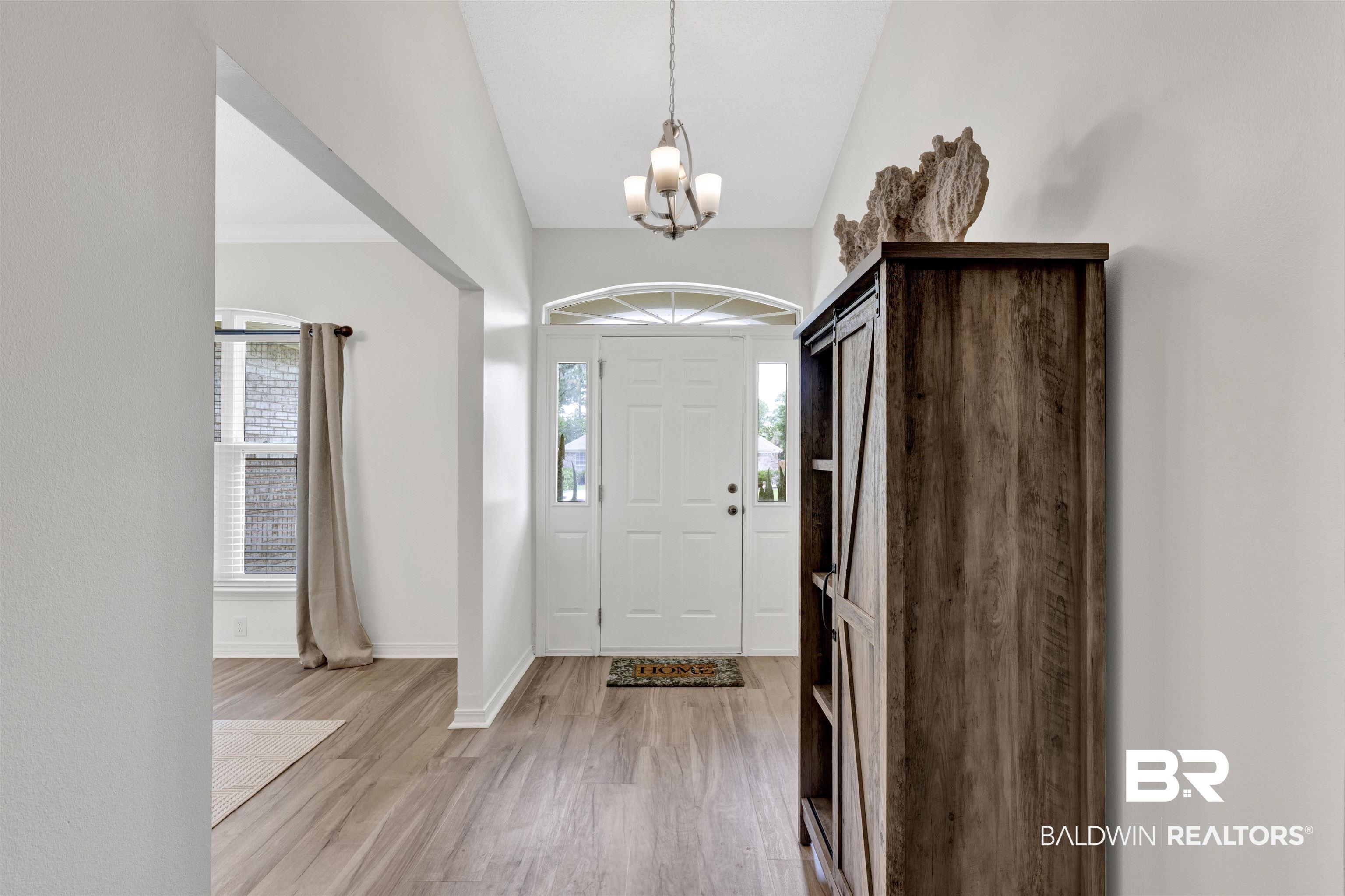 Image 3: Entry foyer with wood-finish flooring and a vaulted ceiling