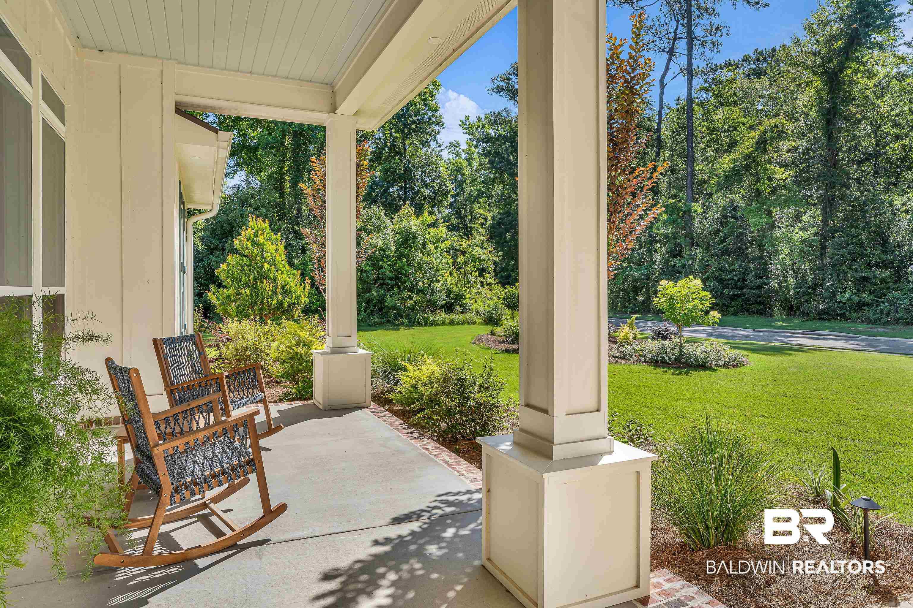 Image 3: Expansive covered front porch featuring a concrete surface, painted support columns, and an exterior siding facade