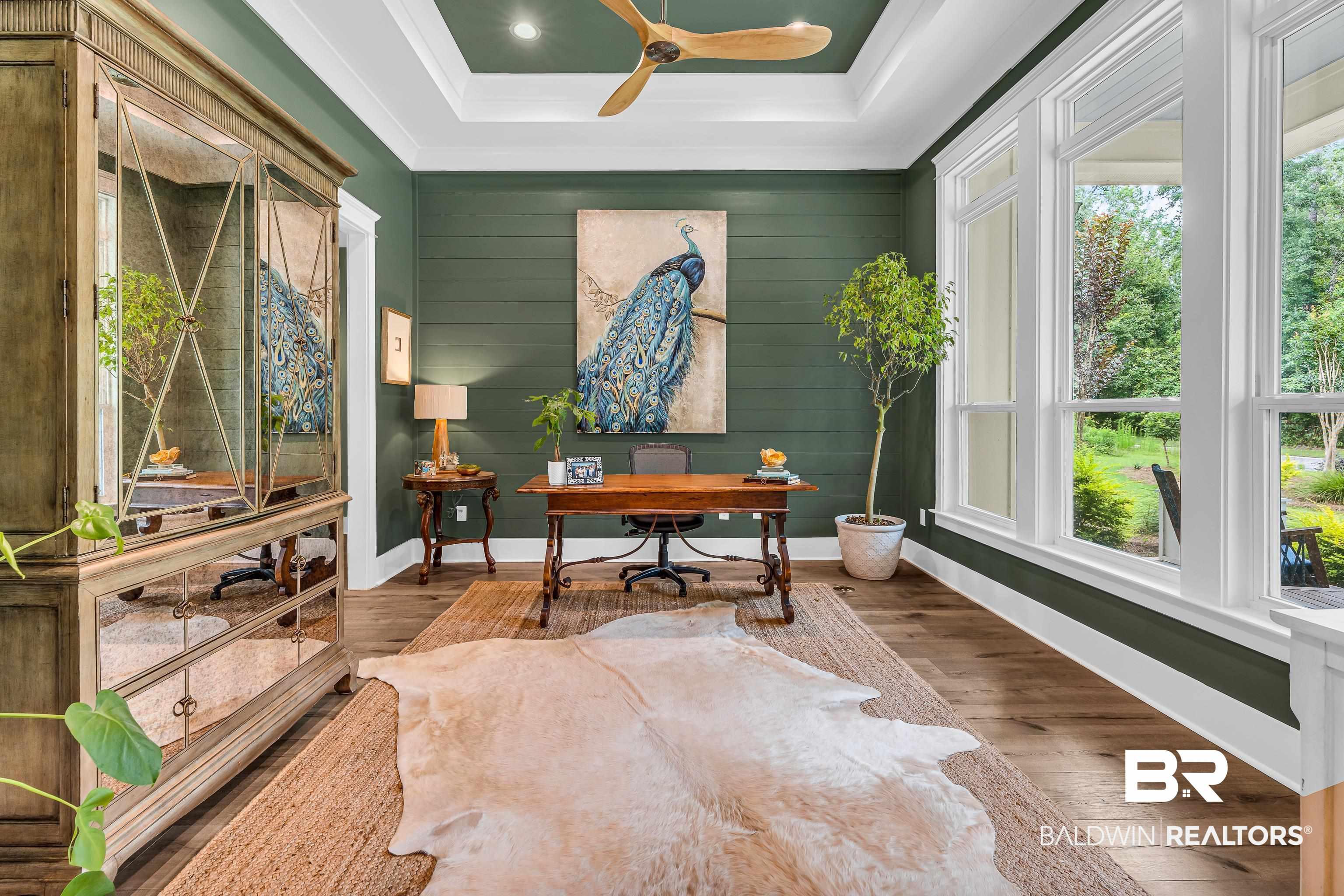Image 4: Hardwood-style flooring throughout this room, featuring a tray ceiling with a ceiling fan, recessed lighting, and large picture windows