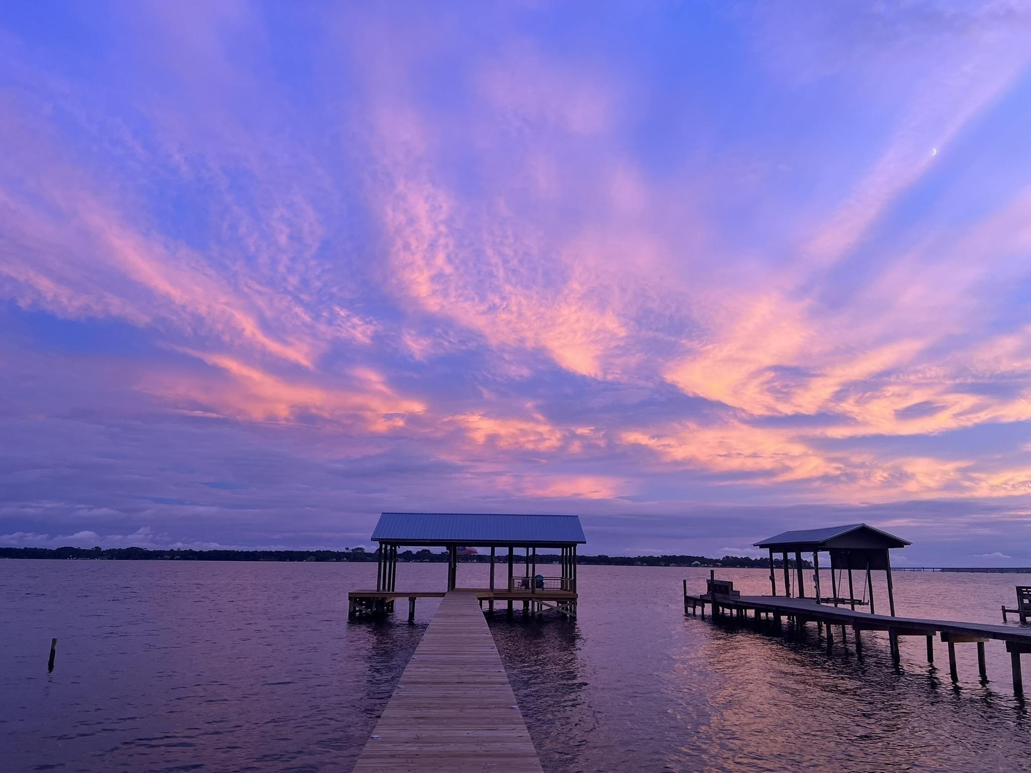 Image 4: What an incredible sunset! Imagine all the sunsets this little slice of paradise can offer. Cozy up with a good book or howl at the moon, this pier has space for it all.