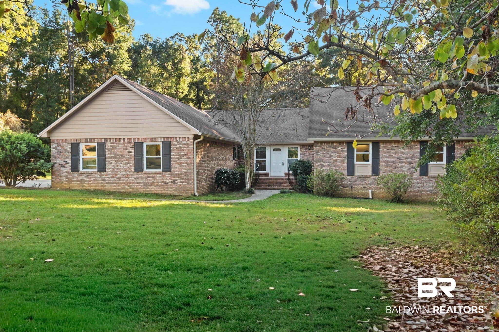 Image 2: Ranch-style home featuring brick siding and a front yard