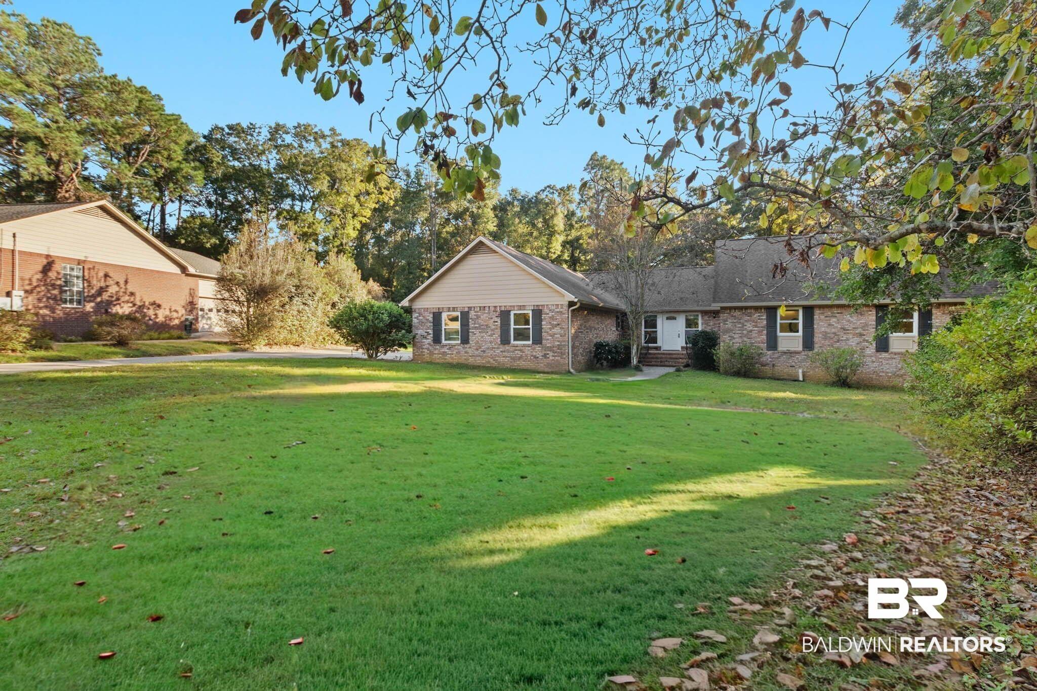 Image 3: View of front of property with a front lawn and brick siding