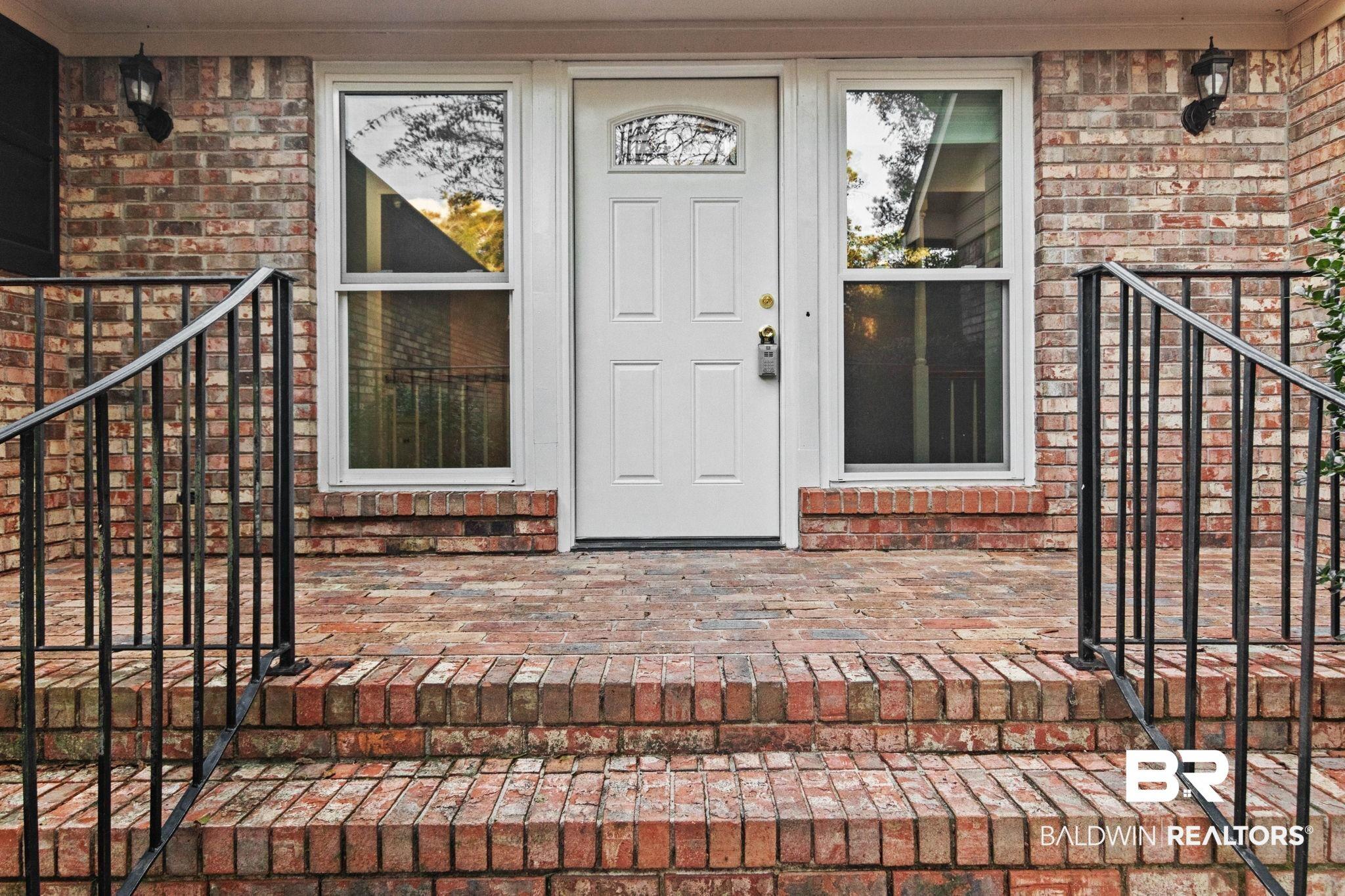 Image 4: View of exterior entry with brick siding