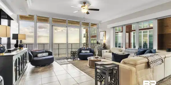 Image 2: Living room with ornamental molding, a ceiling fan, a wall of windows, and light tile patterned floors