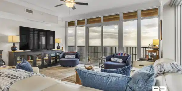Image 4: Living room with a wall of windows, crown molding, wood finished floors, and a ceiling fan