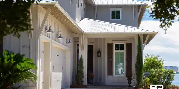 Image 2: Coastal-style exterior featuring board and batten siding and a metal roof