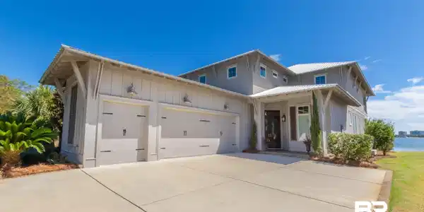Image 3: Contemporary architectural style featuring board and batten siding, a metal roof, and a two-car garage
