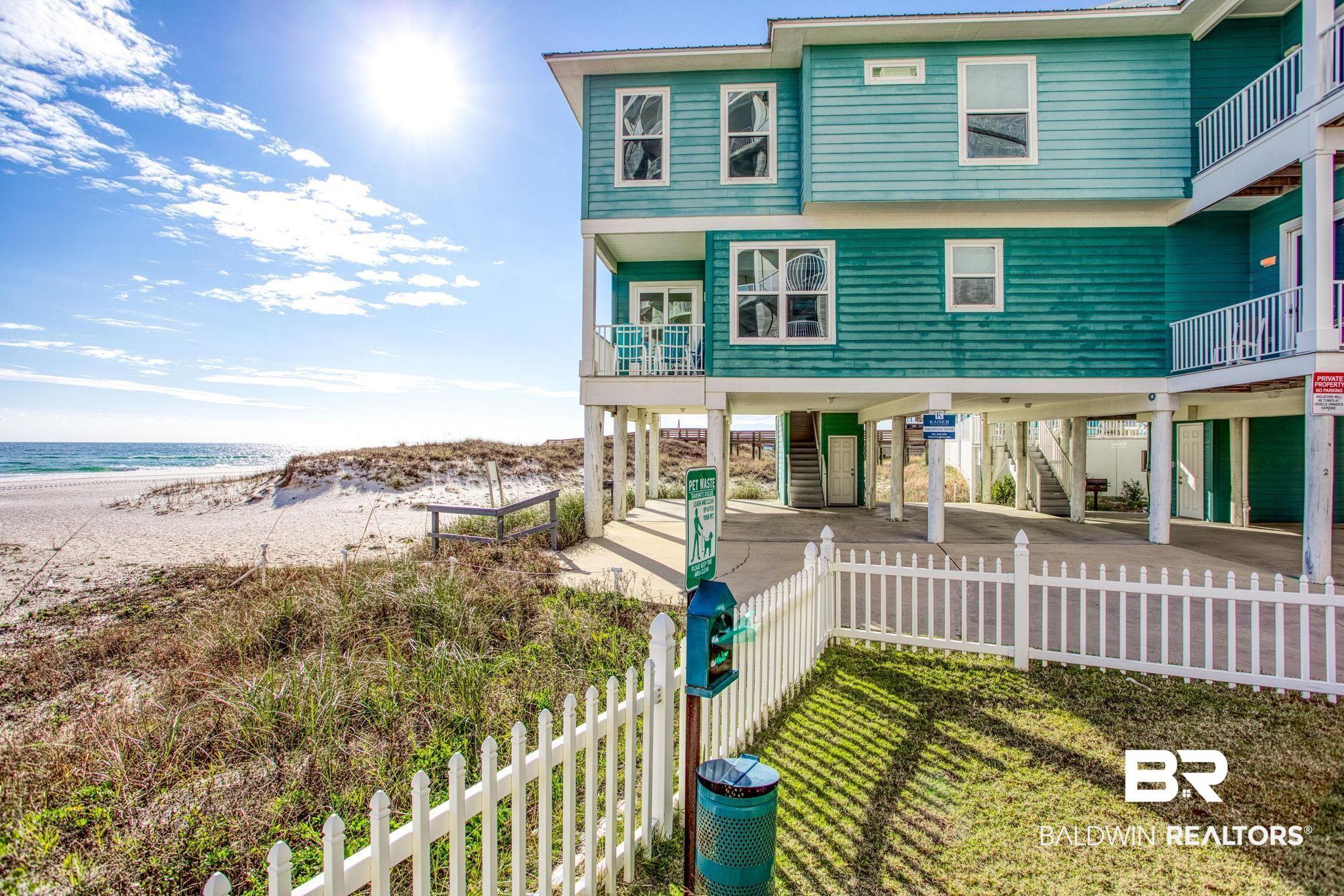 Image 4: Coastal home with a carport, view of water and beach, a balcony, stairs, and a patio