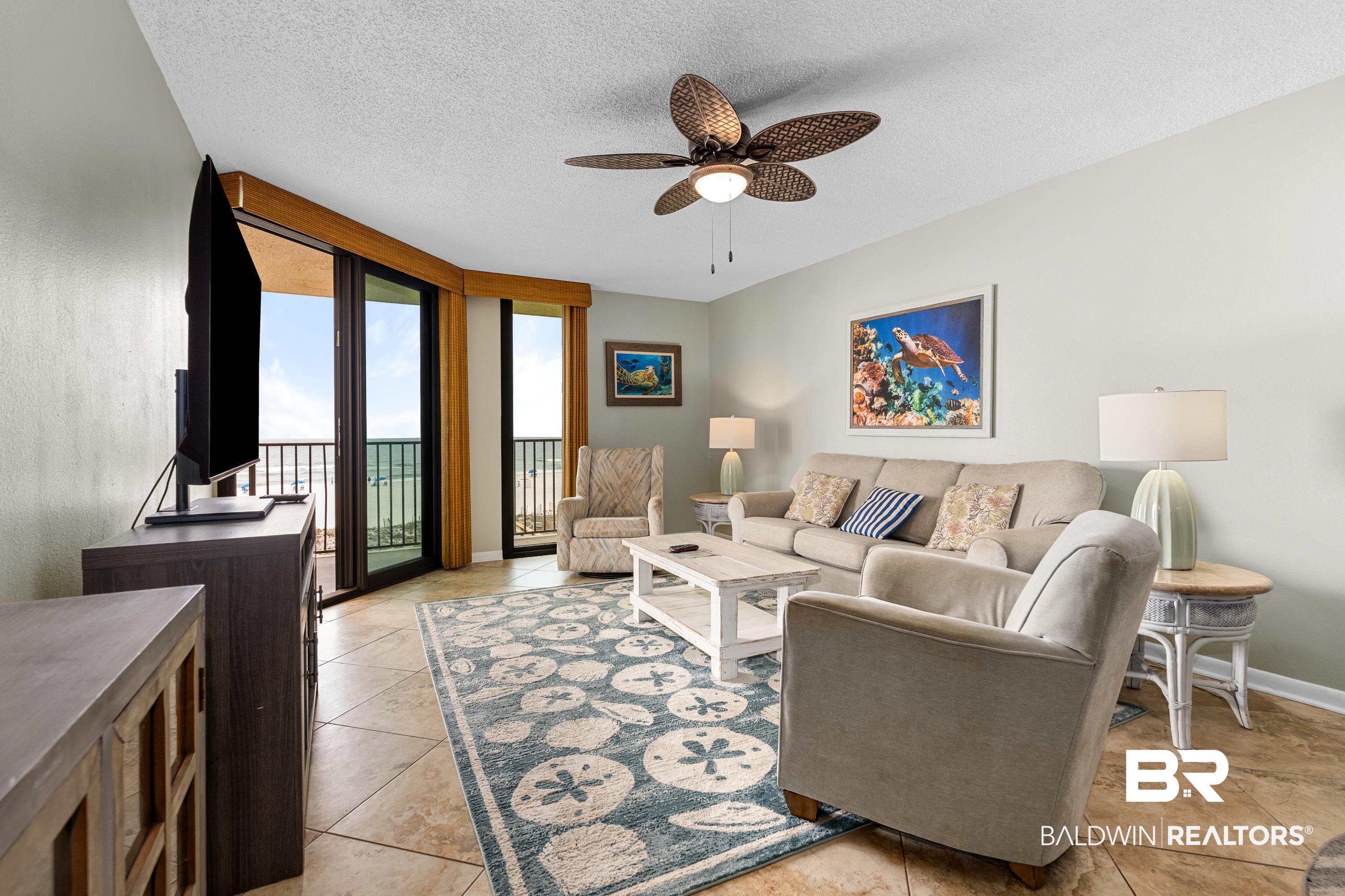 Image 2: Living area featuring tile flooring, a woven ceiling fan with integrated lighting, and light-colored walls