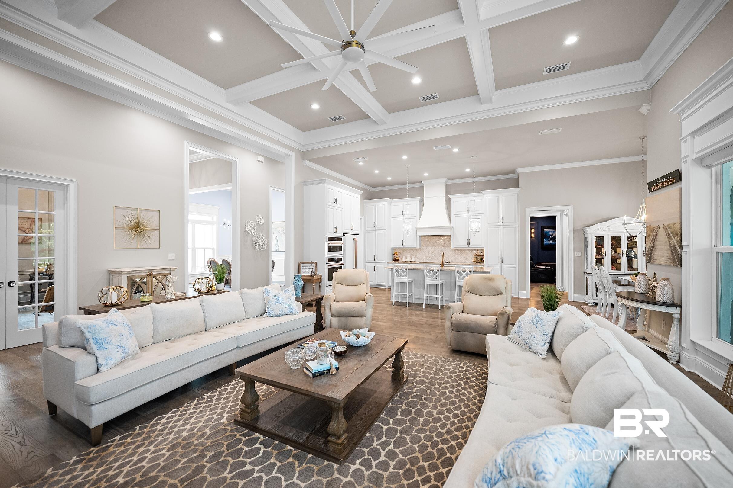 Image 3: Spacious open-concept living area featuring a coffered ceiling with recessed lighting and a large ceiling fan