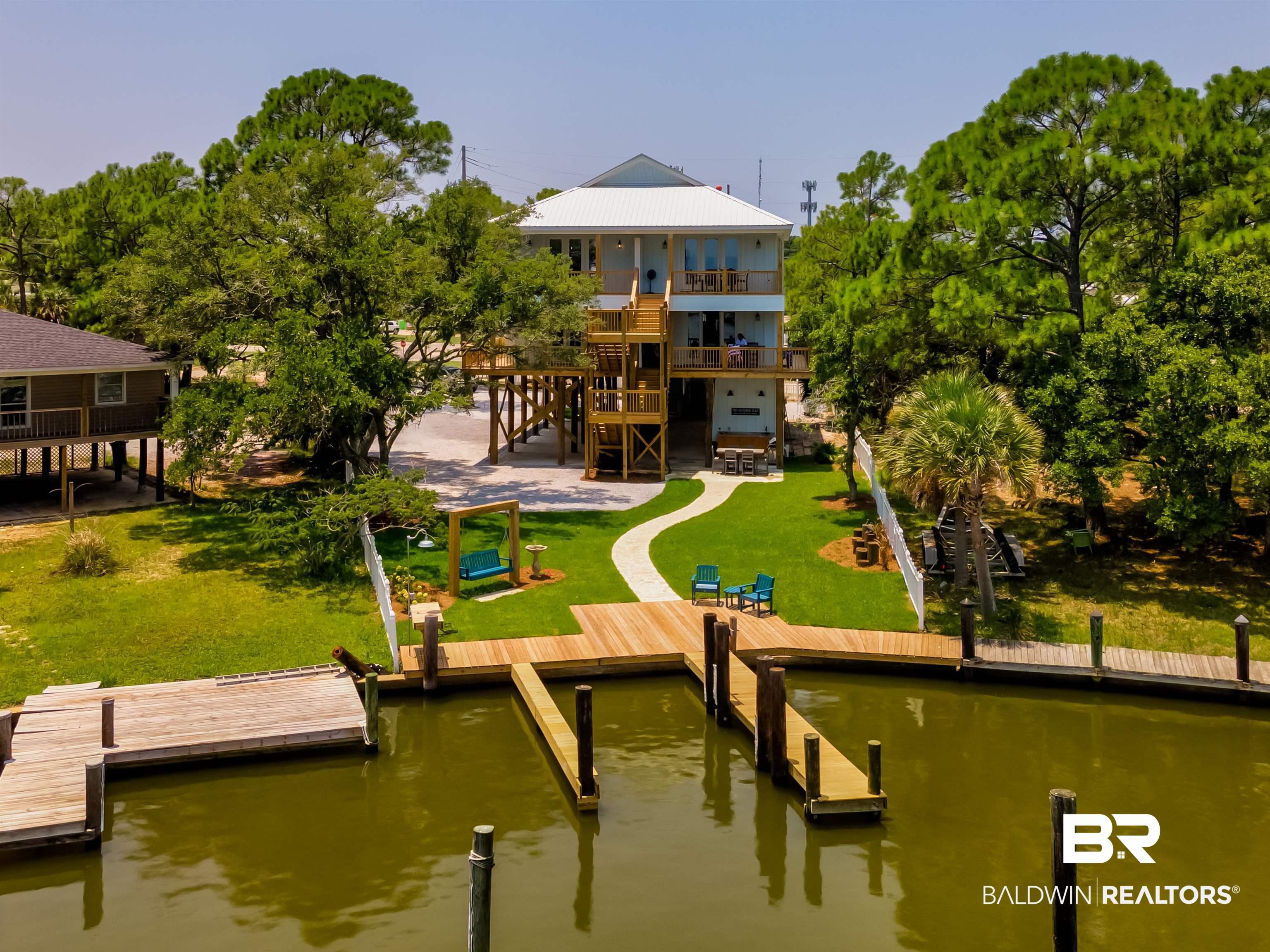 Image 3: Dock with a patio area, a balcony, a lawn, a water view, and stairway