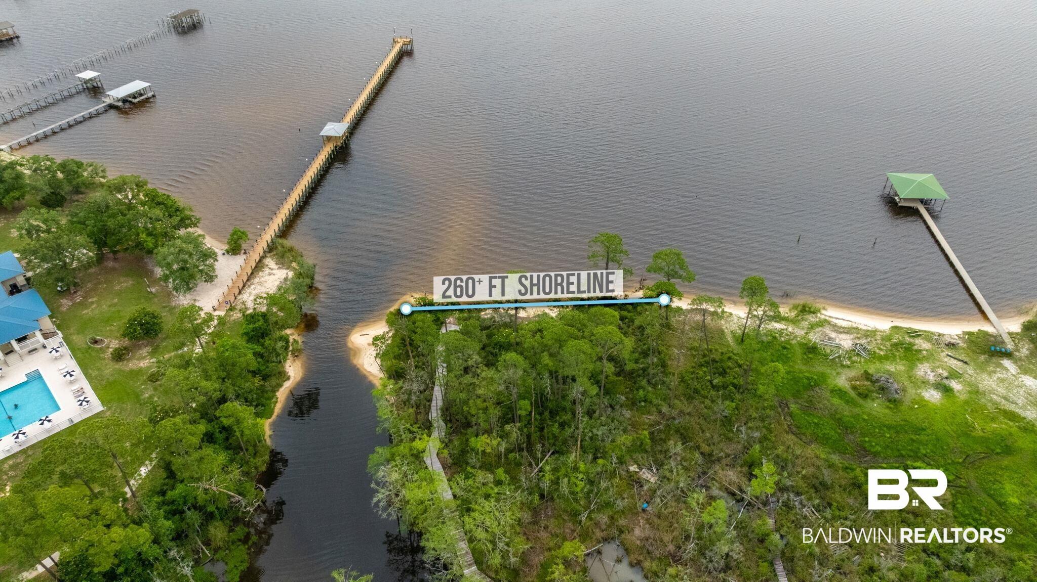 Image 3: Expansive waterfront parcel featuring 260 feet of shoreline, natural sandy beach access, and mature trees